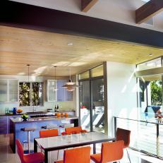 Contemporary Dining Area and Kitchen With Orange Chairs