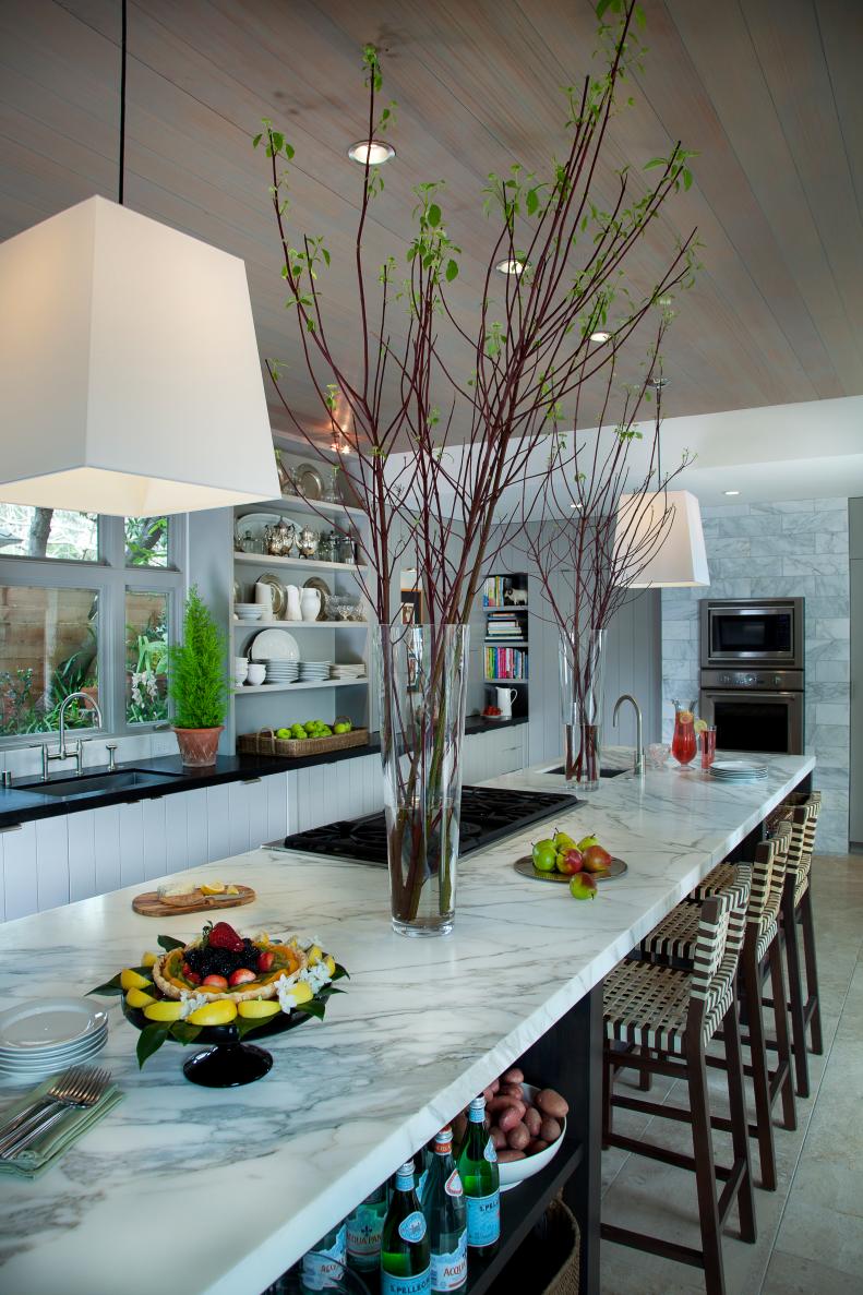 A kitchen island's marble topped eat-in counter
