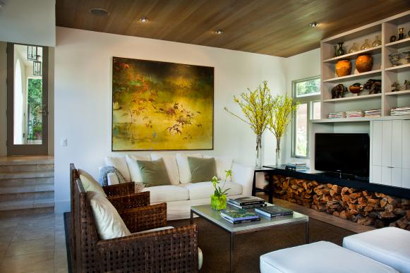 A living room highlighted by flowering branches and firewood