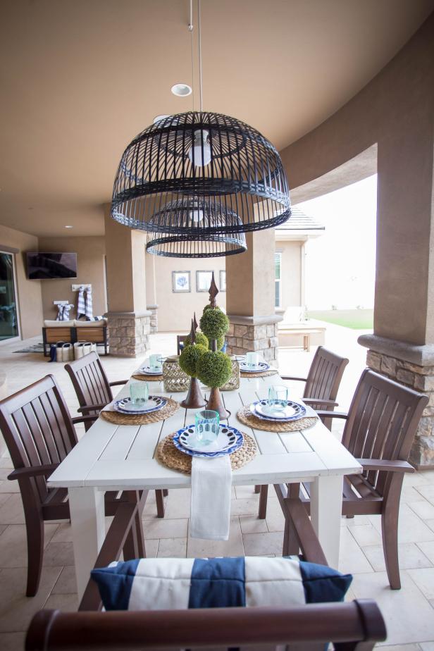 Farmhouse-style seating and basket chandeliers create a fun, casual vibe in this outdoor dining room. A covered patio creates a second living area in this glamorous transitional home.