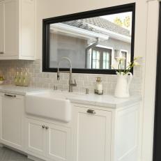 Transitional White Kitchen Features Black Window Frame & Farmhouse Sink