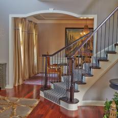 Eclectic Foyer Features Eastern Influenced Cabinet, Sconce & Striking Spiral Staircase