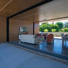 Outdoor View of Modern Living Space With Open Walls & Wood Ceiling 