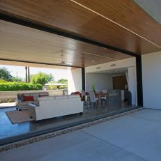 Patio View of Contemporary Living Room With Two Full Glass Walls 