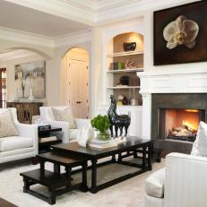Transitional Living Room Features Black Stair-Step Coffee Table and Elegant White Furniture 