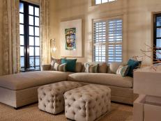Neutral Transitional Family Room With Tufted Ottomans and Blue Accents