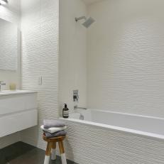 Crisp White Bathroom Boasts Floating Vanity & Textured Tile