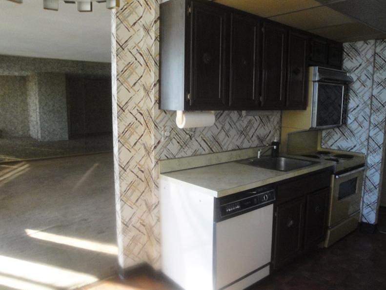 Outdated Kitchen With Graphic Wallpaper & Brown Cabinets