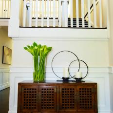 Transitional Foyer With Antique-Style Sideboard