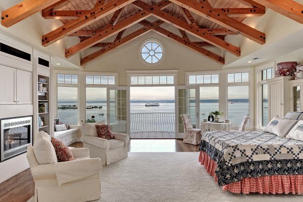 Neutral Bedroom With Hand-Hewn Wood Trusses and Water Views