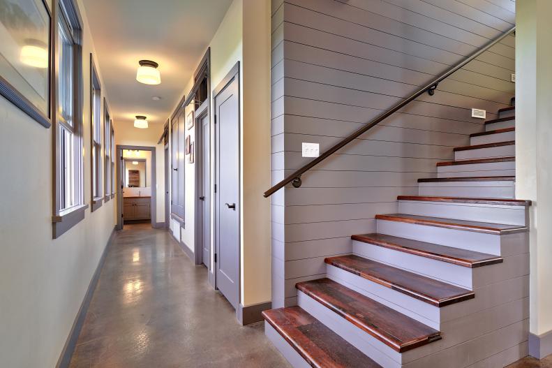 White & Brown Wood Stairs and Narrow Hallway With Concrete Floor