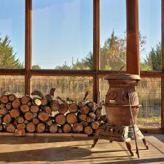 Rustic Screened-In Porch Features Wood-Burning Stove