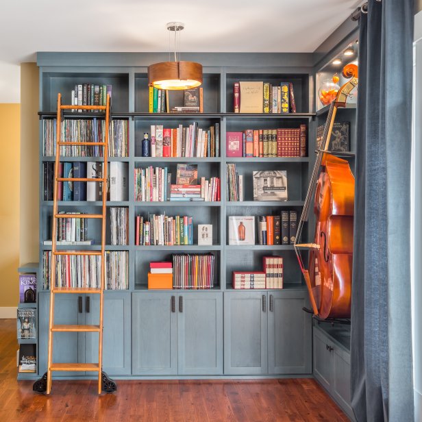 Blue Built-In Bookshelves With Rolling Ladder & Hanging Cello