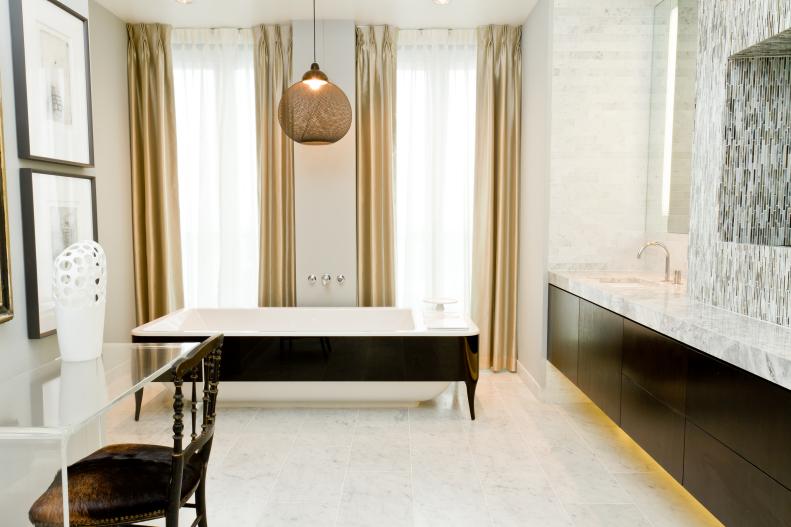 Neutral Bathroom With Black & White Bathtub and Gold Curtains