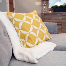 Living Room With Gray Sofa and Yellow Throw Pillow 