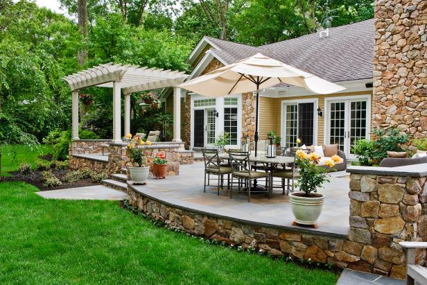 Spanish-Style Backyard With Pergola-Covered Chairs and Dining Table