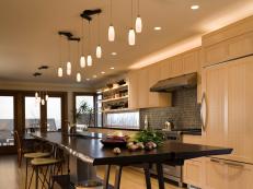 Neutral Kitchen With Pale Wood Cabinets, Dark Island, Pendant Lights
