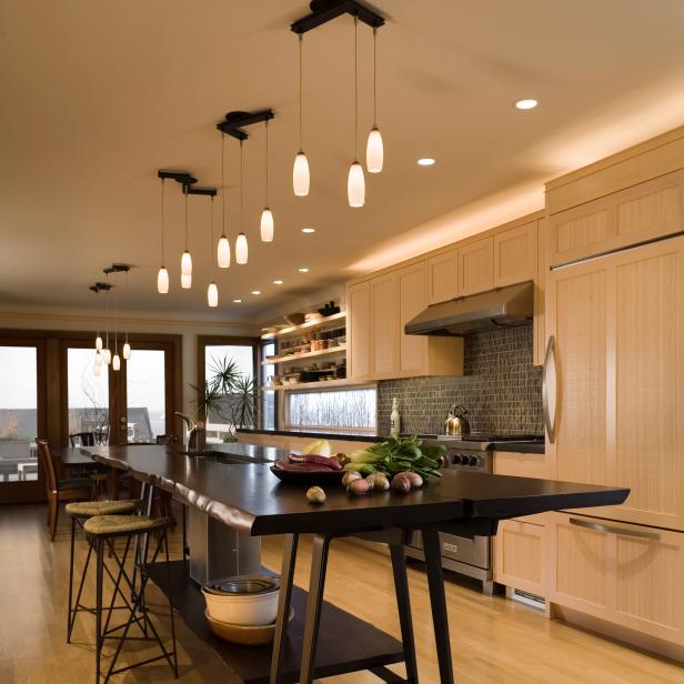 Neutral Kitchen With Pale Wood Cabinets, Dark Island, Pendant Lights