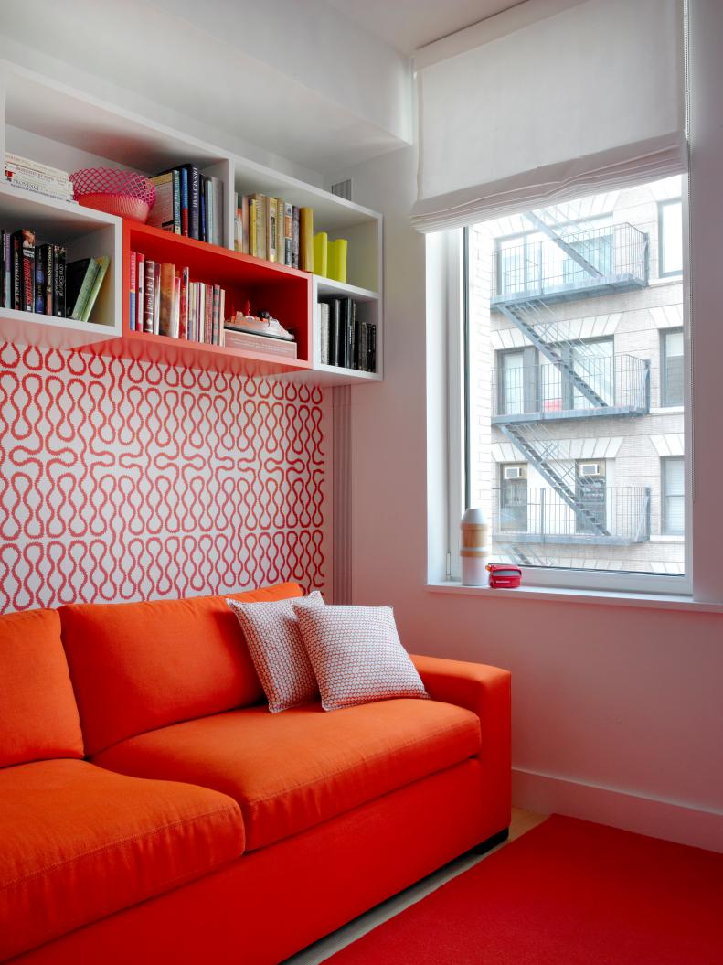 Red Sofa With Graphic Orange & White Wallpaper, Bookshelves