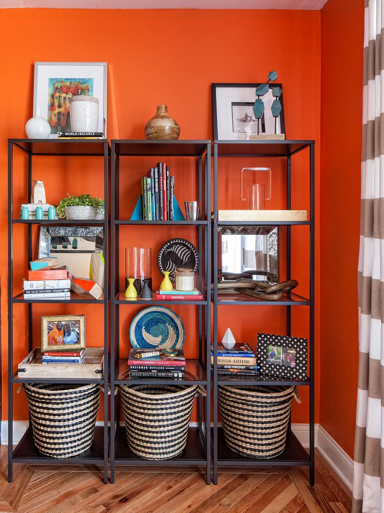 Three Skinny Bookshelves Against Orange Wall