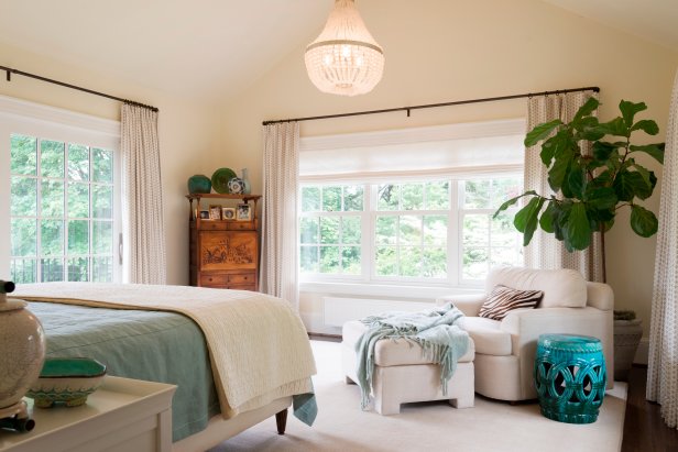 Transitional Neutral Bedroom With Chandelier, White Chair and Ottoman