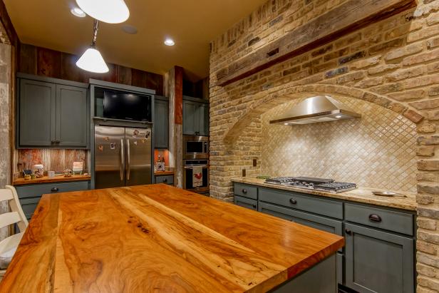 Country Kitchen With Polished Wood Island, Arched Brick Stove Surround and Matte Blue Cabinets 