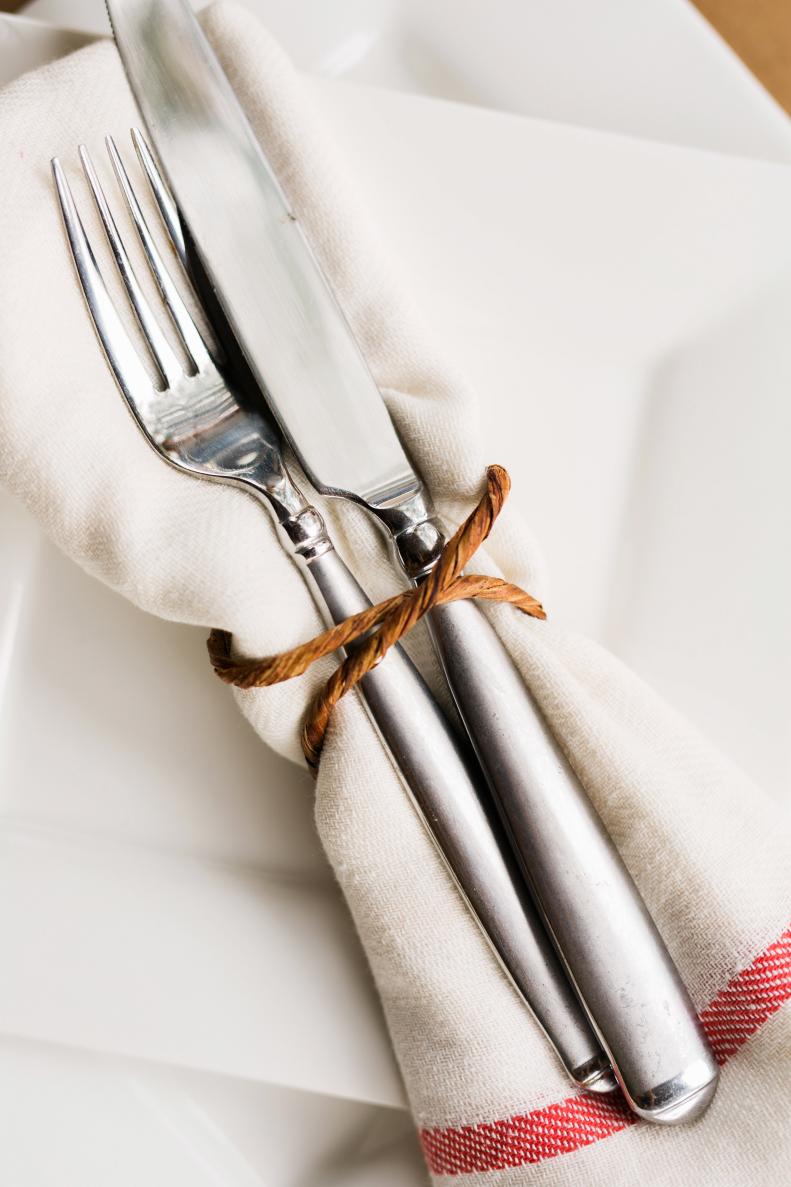 Silverware Wrapped in White Napkin With Red Trim