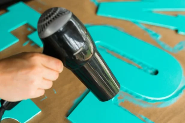 Use a hair dryer to speed up the dry time. Once the first coat is dry to the touch, apply a second coat to the fronts and sides of the letters.