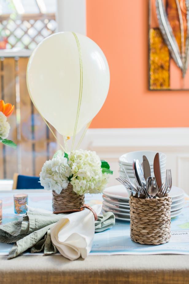 Fresh cut flowers, a small basket, a balloon and some ribbon come together to make a charming centerpiece.