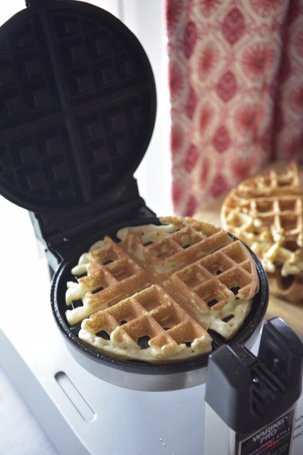 Preheat the waffle iron and prepare the waffle batter mix according to the directions on the package. Once heated, lightly spray the waffle iron with a non-stick cooking spray. Bake four waffles and set them aside on a wire rack.