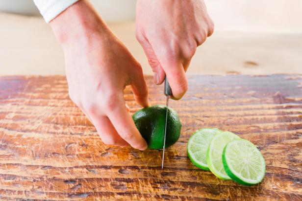 Place the limes, lemons or oranges on a cutting board; then cut them into 1/4&quot; slices using a paring knife.