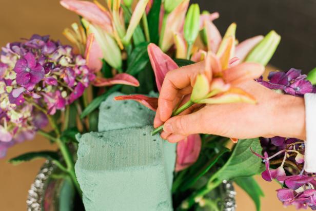 Cut the coordinating flowers to size with floral shears; then place them into the floral foam above the bottom row of flowers.