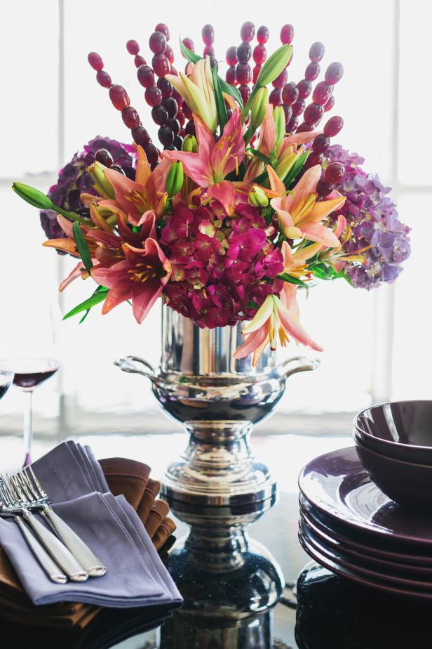 Add an edible touch to an elegant floral arrangement with a mix of fresh flowers topped with grape kebabs. For this project, you'll need: a pewter or silver urn, floral foam, floral shears, utility knife, water, two bunches of hydrangea, two bunches of lilies, two bunches of grapes, package of 12 kebabs and measuring tape.