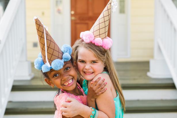 Two Girls Hugging With Paper Cone Party Hats