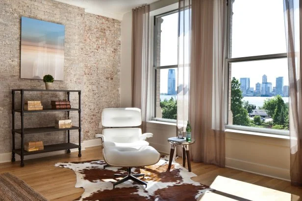 Neutral Contemporary Living Room With Brick Wall & White Chair