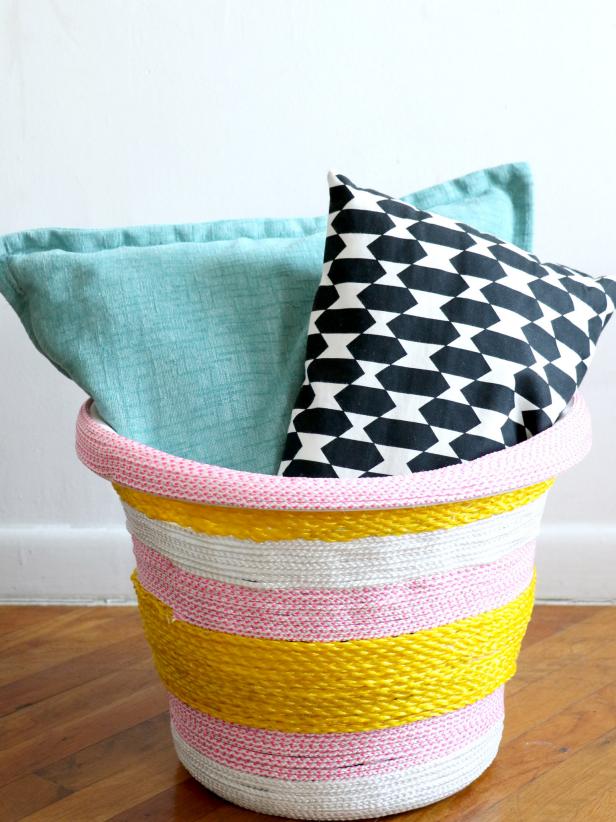 A basic, inexpensive plastic laundry basket is made whimsical and colorful with stripes of rope. Look for fun rope in your local hardware store. Experiment with a variety of colors and thicknesses to match your decor.