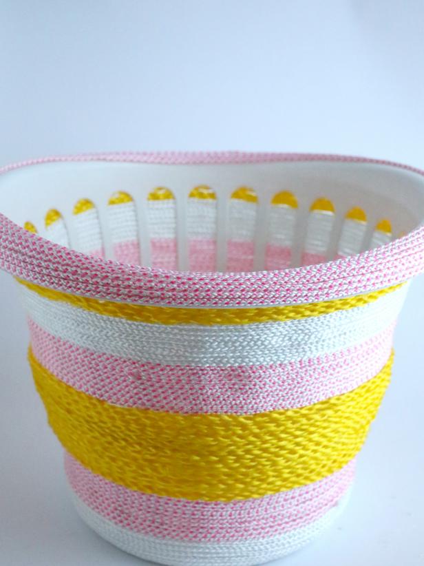 Wrap and glue the rope under the rim of the basket. Then, start wrapping and gluing the rope on the rim of the basket.
