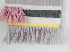 Vintage-inspired flat-weave textiles are back in style and we couldn't be happier. Make your own custom wall hanging using a wooden handloom and various colors of yarn. Embellish with the season's hottest trends – fringe and stripes.