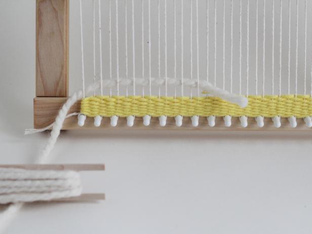 To switch colors, thread your next color halfway through the shed. Leave the tail of the yarn behind the tapestry. Weave a few inches of stripes in different colors.