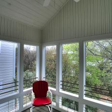 Traditional Screened-In Porch Features Red & White Metal Armchair