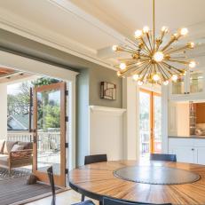 Open Dining Room Boasts Modern Chandelier & Deck Access
