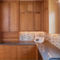 Warm Wood Kitchen Cabinetry Pairs With Mosaic Backsplash