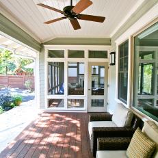 Covered Porch Features Wicker Armchairs & Dark Wood Flooring
