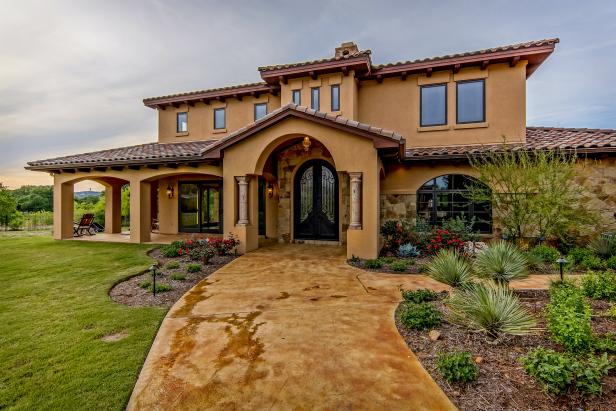 Wide Walkway Leads to Mediterranean Home With Stucco Facade