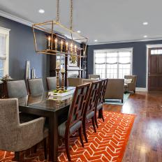 Transitional Navy Dining Room Features Bold Orange Rug