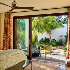 Guest Bedroom With Sliding Glass Door Leading to Tropical Garden