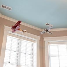 Blue Ceiling With Hanging Model Airplanes in Boy's Bedroom