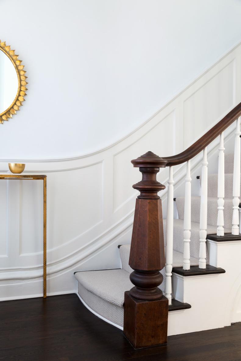 Stairway With White Wainscoting and Brown Handrail