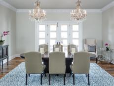 Transitional Neutral Dining Room With Two Chandeliers and Blue Rug