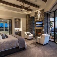 Rustic En Suite Bedroom With Stacked Stone Fireplace